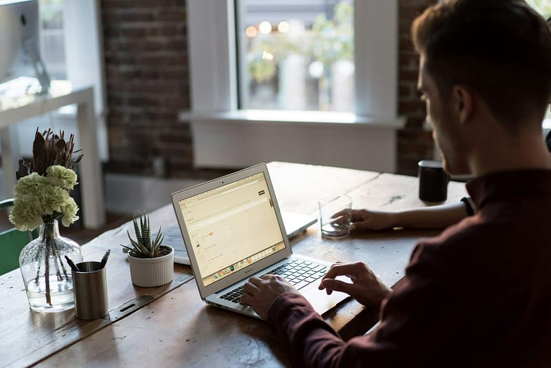 bench-accounting-C3V88BOoRoM-unsplash Man sitting at wooden desk on his computer